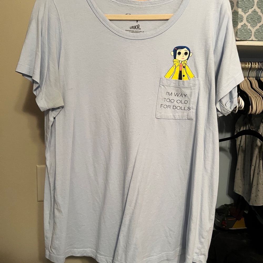 CORALINE Light Blue Pocket Tee with Yellow Doll Graphic